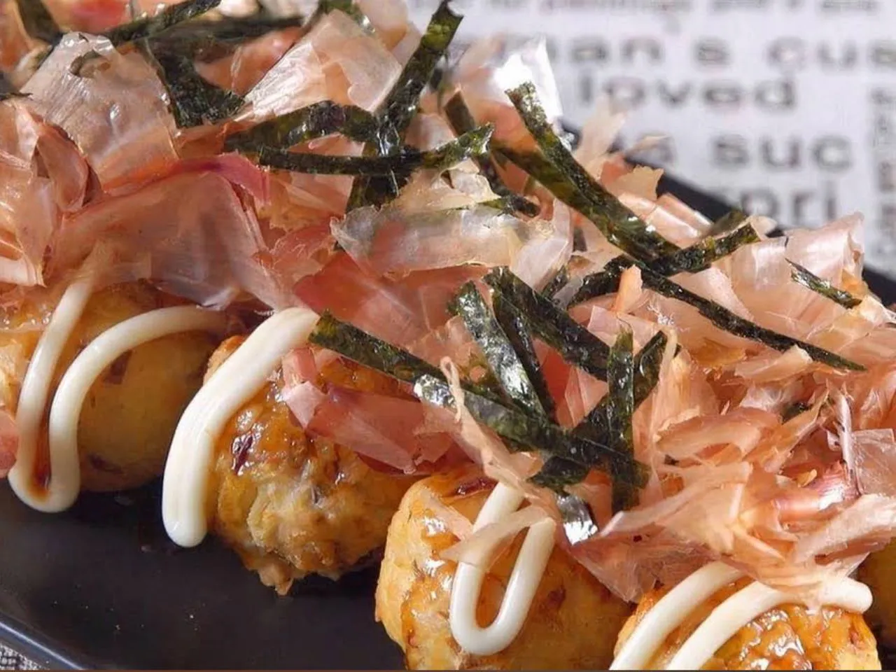 Savory takoyaki octopus balls topped with bonito flakes and seaweed strips at Over The Rainbow Tea Bar, a Tea House in Renton